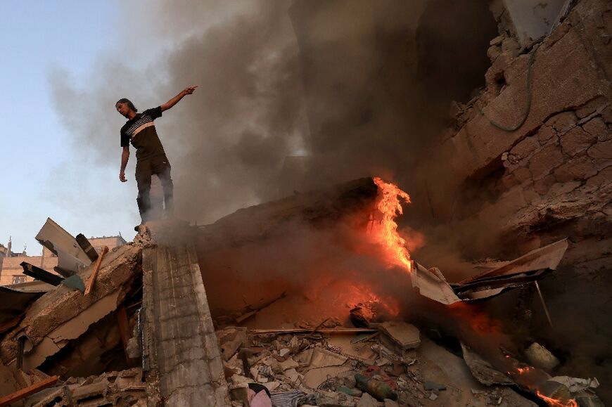 A man stands on the rubble of a collapsed building after a strike on Khan Yunis on November 4