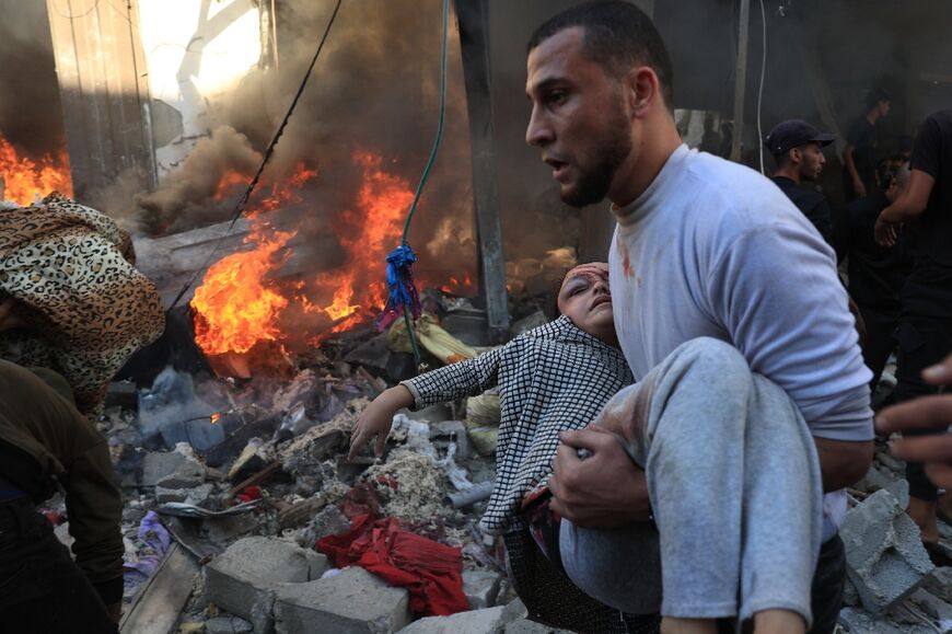 A man evacuates a wounded girl after bombardment in Rafah on November 17