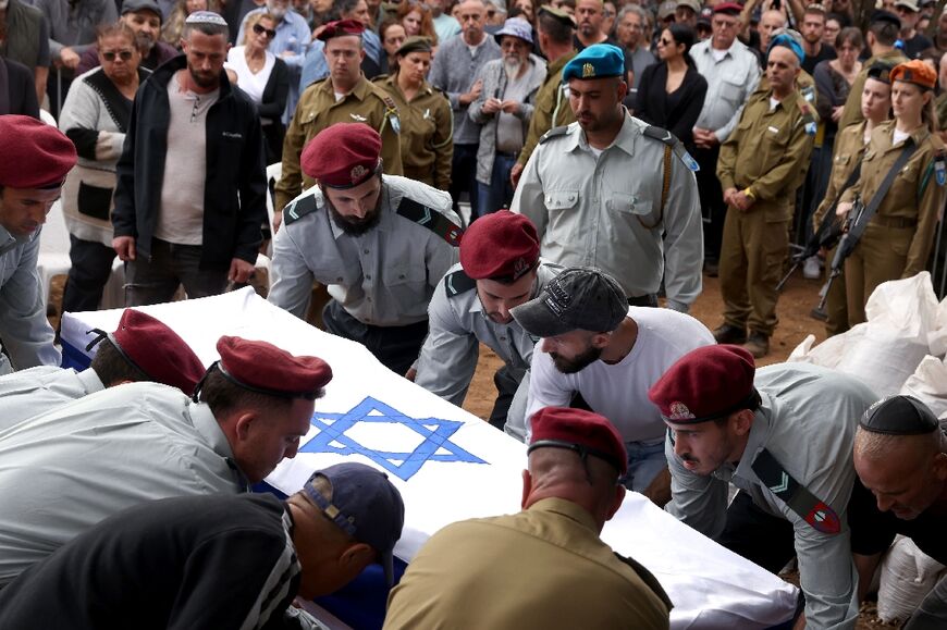 Israeli soldiers and civilians attend the funeral of Matan Meir, a member of the "Fauda" production team who was killed in combat while on reserve duty for the Israeli army in Gaza, on November 13, 2023 at Moshav Odem in the annexed Golan Heights.