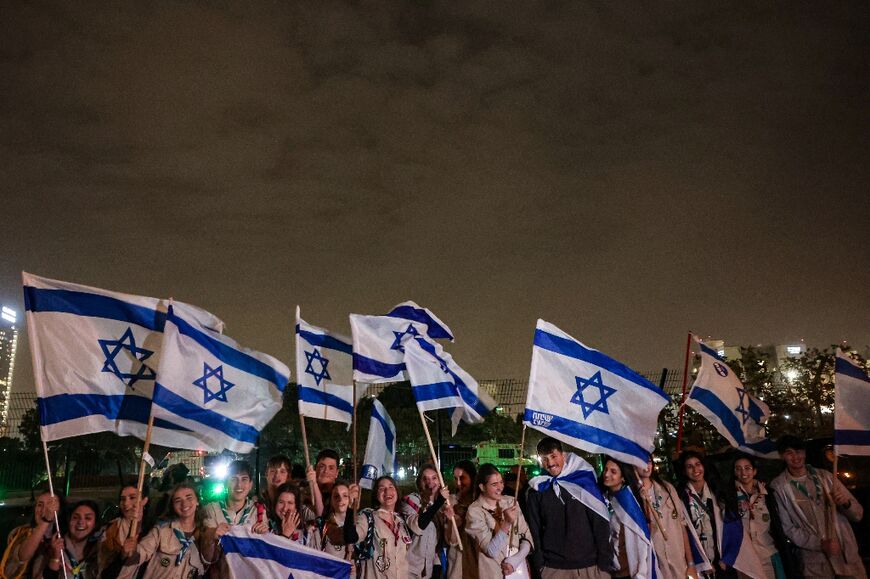 Israeli scouts wave flags of Israel next to the Schneider Hospital as they wait for the release of hostages in Petah Tikva near Tel Aviv