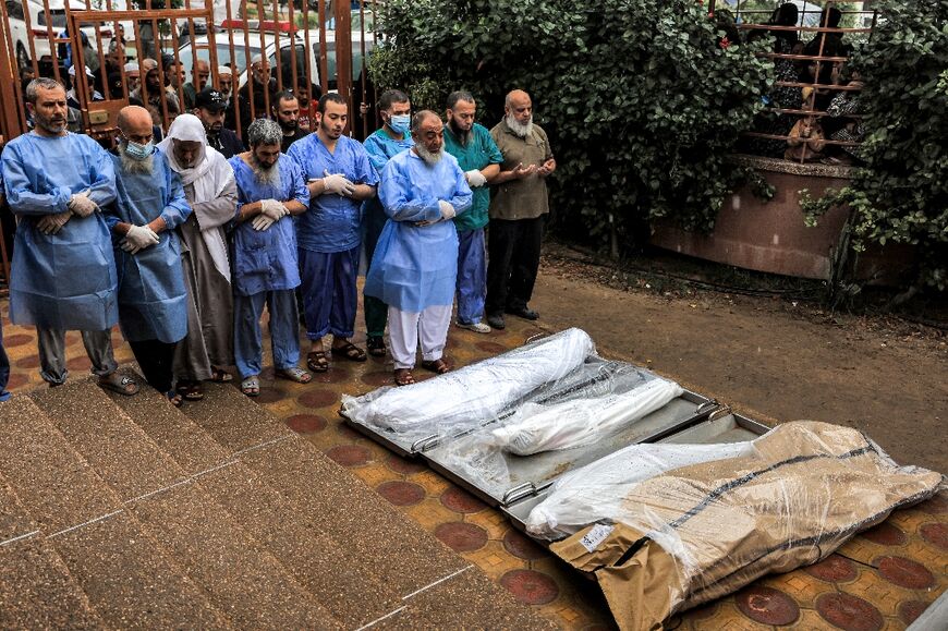 Physicians and other men are seem praying before bodies outside the morgue, in this file picture from November 14