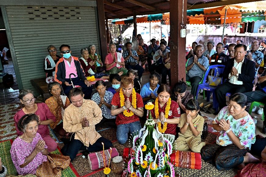 Freed Thai couple Boonthom Pankhong (centre L) and Natthawaree Mulkan (centre R) take part in a traditional welcoming ceremony for their safe return to Thailand