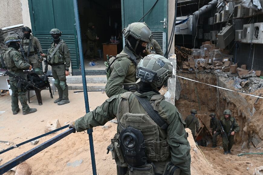 --PHOTO TAKEN DURING A CONTROLLED TOUR AND SUBSEQUENTLY EDITED UNDER THE SUPERVISION OF THE ISRAELI MILITARY-- Israeli troops surround what the army says is the entrance to a tunnel dug by Hamas militants inside the Al-Shifa hospital complex