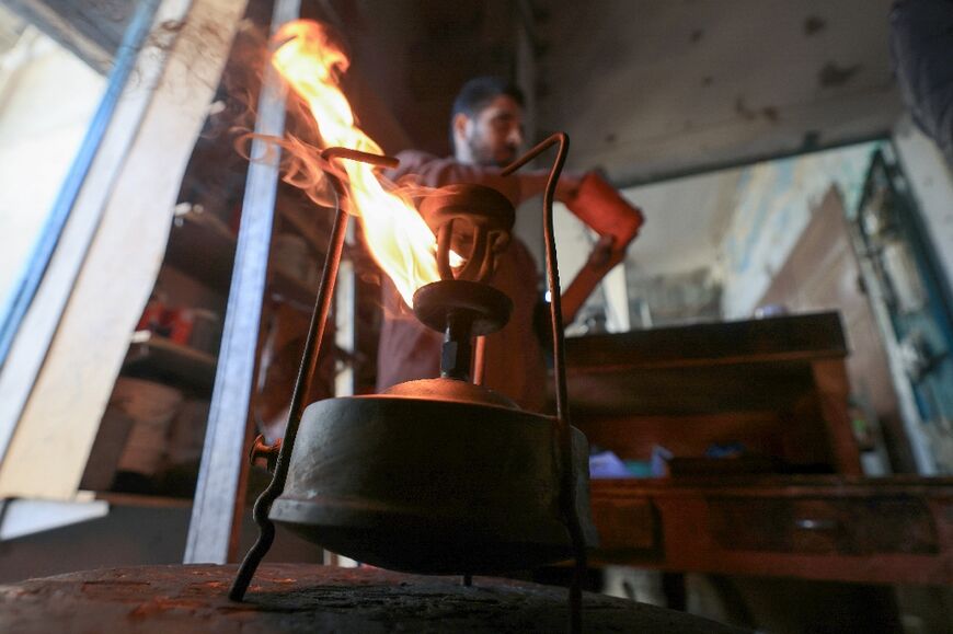 In one Gaza workshop, motor oil and home heating oil are used to start up the brass stoves amid shortages of kerosene