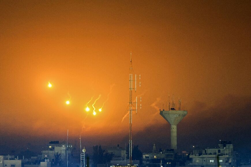 A picture taken from Rafah shows flares and smoke over Khan Yunis
