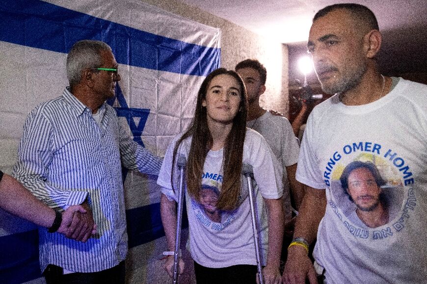 Released Israeli hostages siblings Maya (C) and Itay (C back) Regev arrive at their family home in Herzliya near Tel Aviv, after spending a few days in hospital following their release from captivity by Hamas