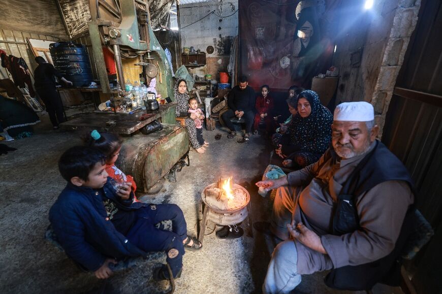 A Palestinian family who fled from Gaza City to Khan Yunis and then to Rafah, in the southern Gaza Strip, found temporary shelter inside a workshop A Palestinian family who fled from Gaza City to Khan Yunis and then to Rafah, in the southern Gaza Strip, found temporary shelter inside a workshop