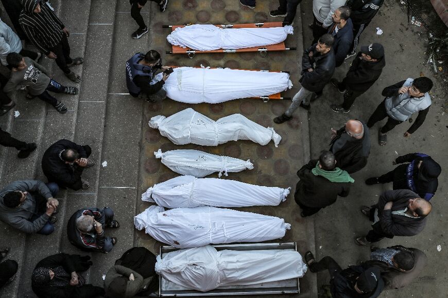 Mourners stand by shrouded bodies of relatives at Khan Yunis's Nasser hospital Mourners stand by shrouded bodies of relatives at Khan Yunis's Nasser hospital