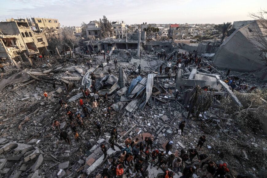 Palestinians stand amid the rubble of a mosque and buildings which collapsed during Israeli bombardment in Rafah