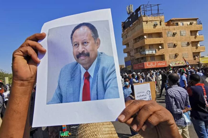 During a demonstration in Khartoum on November 13, 2021, a Sudanese anti-coup protester carries a portrait of Prime Minister Abdalla Hamdok, who was under house arrest