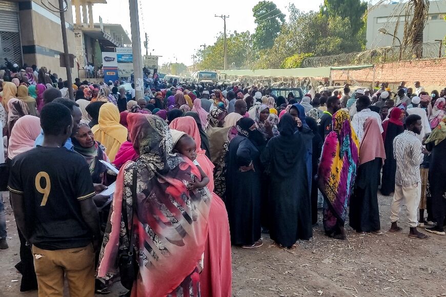 Displaced Sudanese queue for aid in Gedaref, in the country's east, after paramilitaries pressed further into Al-Jazira state