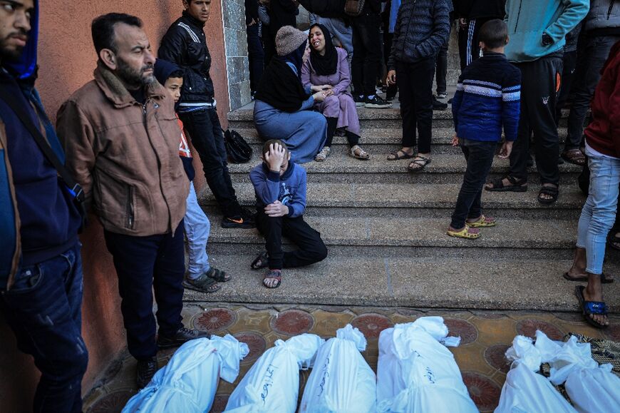 People gather around the bodies of the Salah and Abu Hatab families, killed when the tent where they were sheltering was hit by Israeli bombardment, at a morgue in Khan Yunis on January 4, 2024