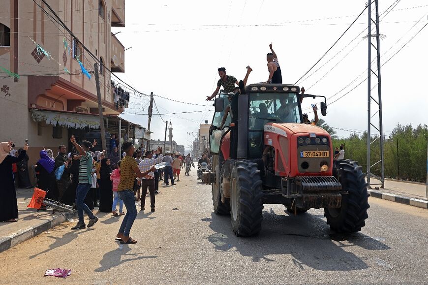 Palestinians in Khan Yunis, southern Gaza, on October 7, 2023 drive an Israeli tractor seized after militants breached the border fence with Israel 