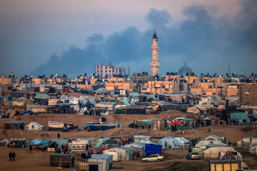 Seen from a makeshift camp for displaced Palestinians, west of Rafah near the Egyptian border in southern Gaza, smoke billows from Khan Yunis following Israeli bombardment