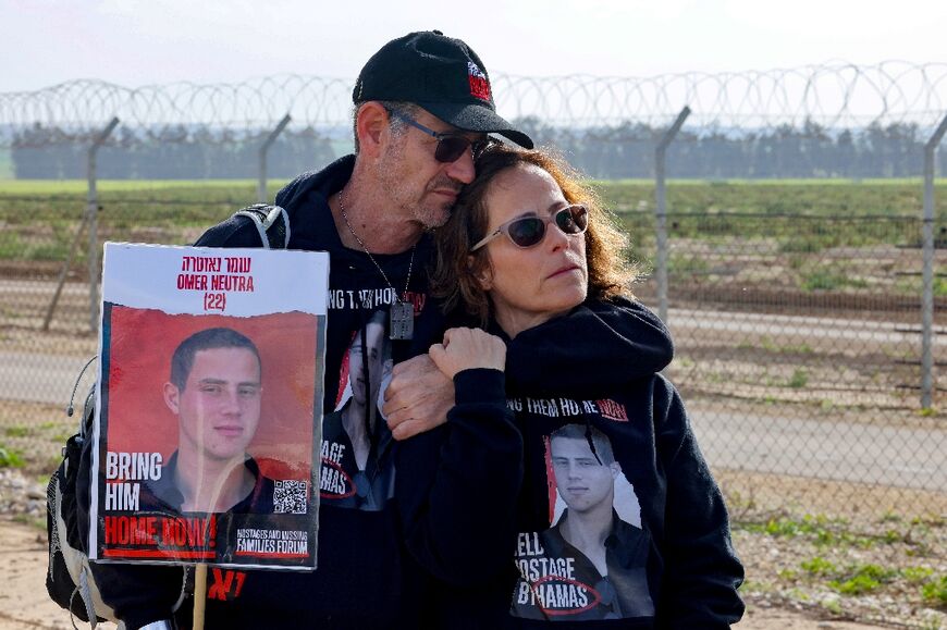 Relatives of Israeli hostages held by Hamas hold a picture of Omer Neutra, 22, in Kibbutz Nirim along the Gaza border fence