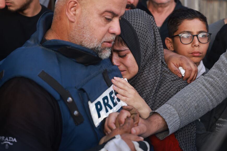Al Jazeera's bureau chief in Gaza, Wael Al-Dahdouh (C) hugs his daughter during the funeral of his son Hamza Wael Dahdouh, a journalist with the Al Jazeera television network, who was killed in a reported Israeli air strike in Rafah in the Gaza Strip on January 7, 2024. Dahdouh, who was himself wounded in the arm, lost his wife and two other children in Israeli bombardment in the initial weeks of the war. (Photo by AFP) (Photo by -/AFP via Getty Images)