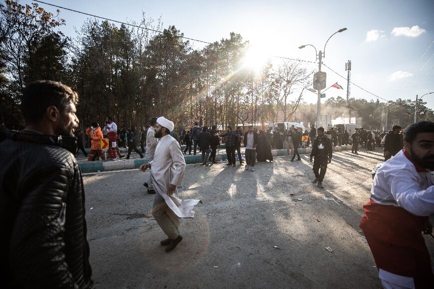 People disperse near the site where two explosions in quick succession struck 