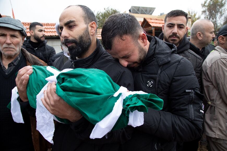 Mourners attend a funeral after a woman and two children were killed in a strike on Lebanon's Sawwaneh