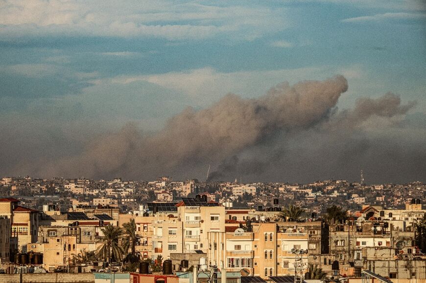 A picture taken from Rafah in the southern Gaza Strip shows smoke rising over buildings in Khan Yunis during Israeli bombardment on February 2