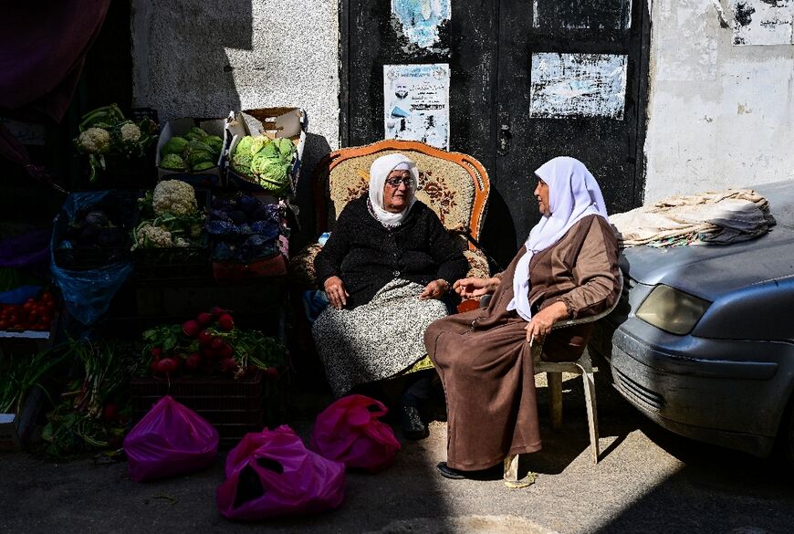 A Palestinian vendor chatting with a customer in Jenin refugee camp during the Muslim fasting month of Ramadan