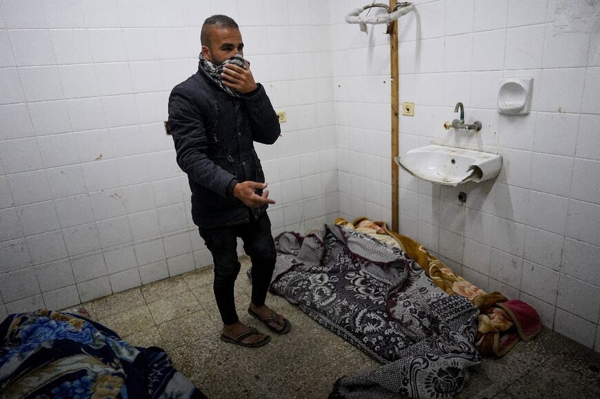 A Palestinian man reacts near bodies on the floor of a hospital in Zuwayda, the central Gaza Strip 