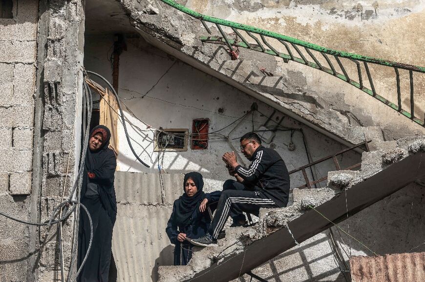 Palestinians sit in a damaged building following overnight Israeli bombardment in Rafah, in the southern Gaza Strip, on March 27, 2024