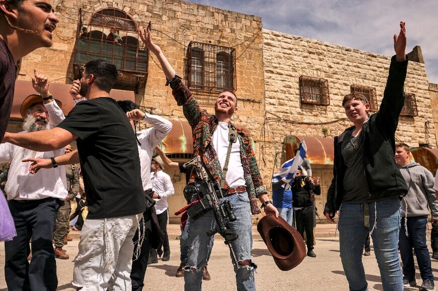 Israeli settlers dressed in Purim costumes on Al-Shuhada Street, which is largely closed to Palestinians in the divided city of Hebron, in the Israeli-occupied West Bank during celebrations of the Jewish holiday of Purim 