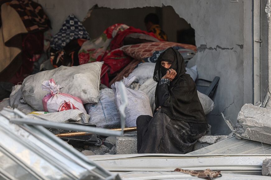A Palestinian woman sits amid the rubble of her flat after an overnight strike on Rafah in the southern Gaza Strip