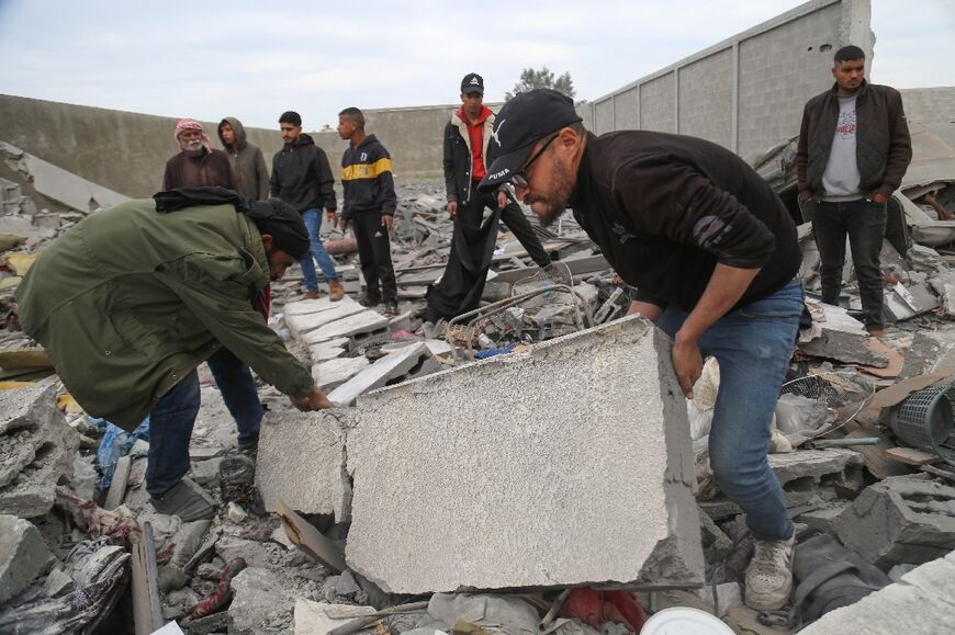 Palestinians use their bare hands to search for the dead under the rubble for lack of proper equipment