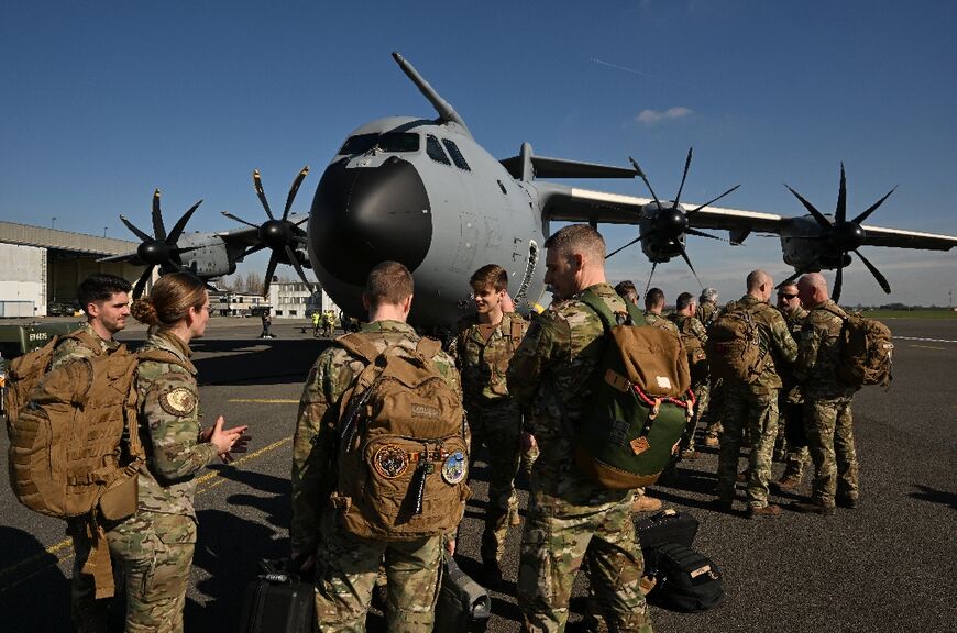 Soldiers stand by a Belgian military transport aircraft loaded with humanitarian aid to be dropped over Gaza, prior to its takeoff from Melsbroek, Belgium
