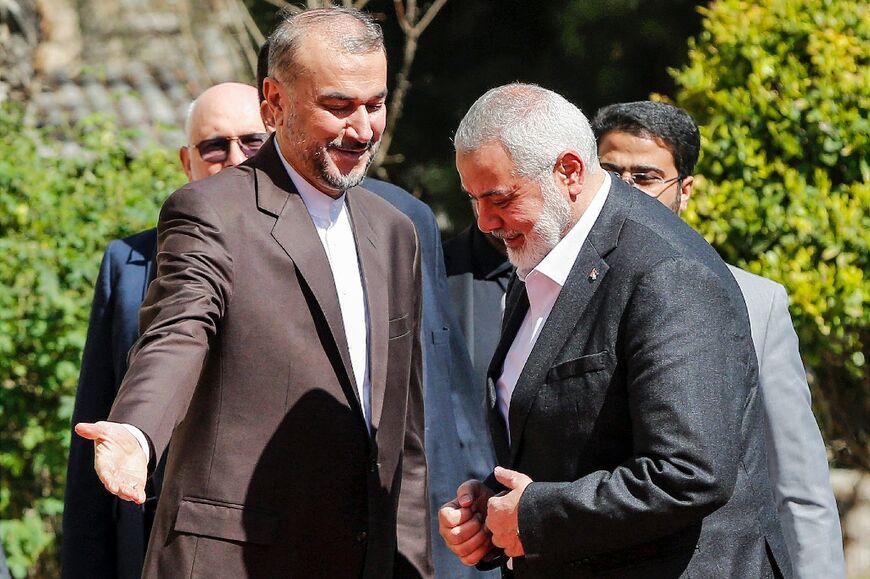 Iranian Foreign Minister Hossein Amir-Abdollahian (L) welcomes Hamas leader Ismail Haniyeh on his second visit to Tehran since the Gaza war broke out in October
