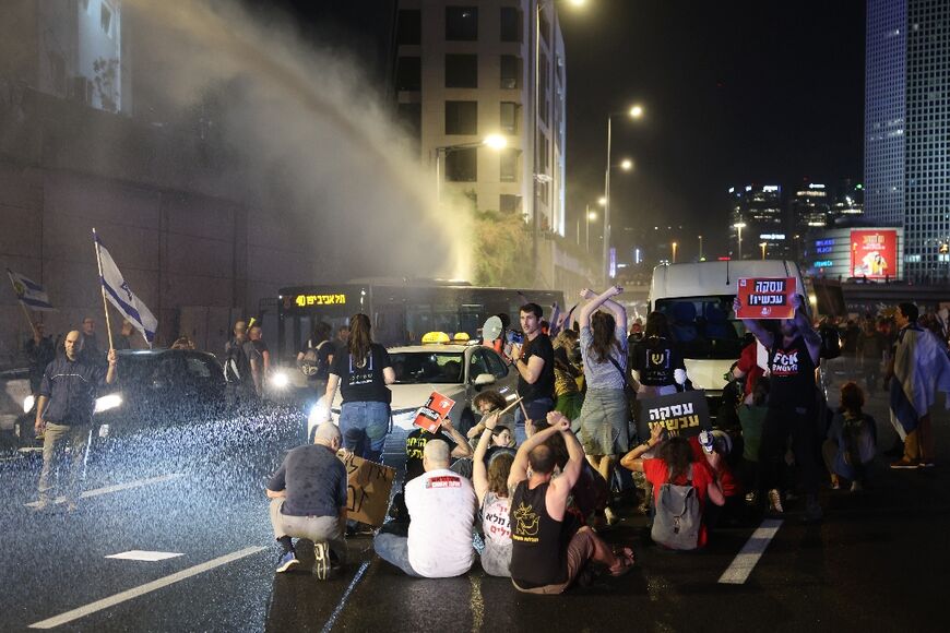 Israeli police use water cannon on anti-government protesters blocking the Tel Aviv ring road 