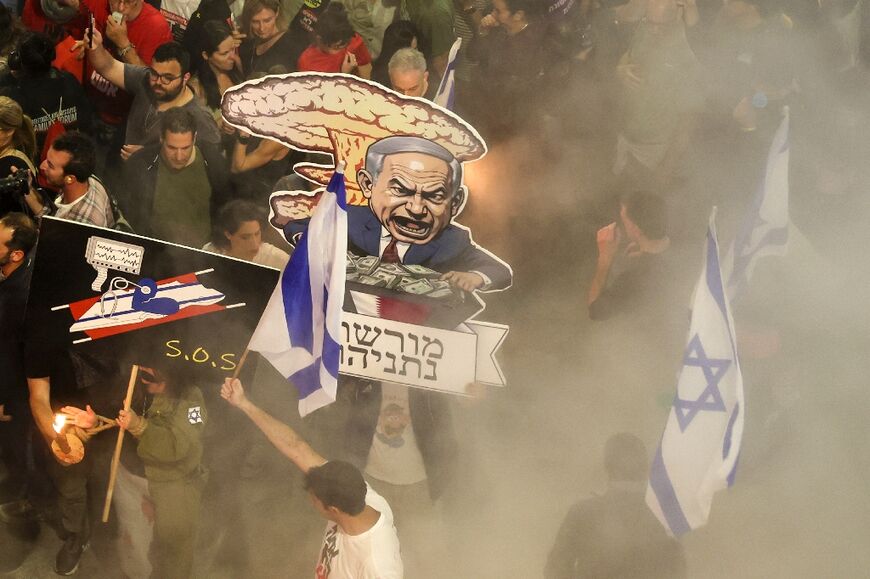 Israeli protesters demonstrate against the government's conduct of the Gaza war, holding up caricatures of Israeli Prime Minister Benjamin Netanyahu and demanding a snap election