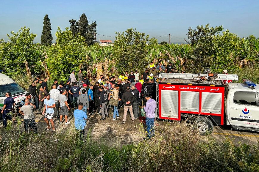 People gather at the site of an Israeli strike on Lebanon's Adloun plain area