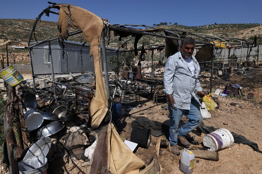 A Palestinian inspects the damage to his property by Israeli settlers in Al-Mughayyir