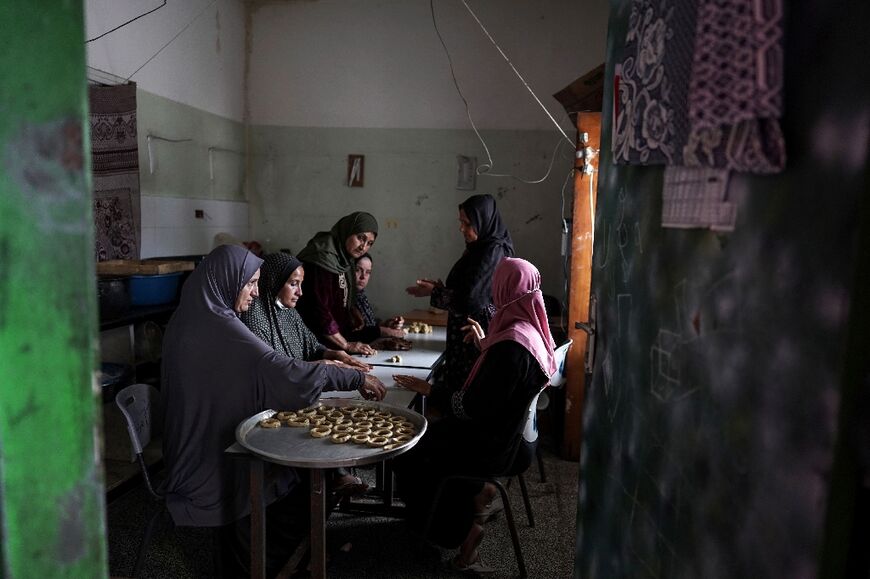 Palestinian women prepare traditional cookies ahead of Eid al-Fitr, which marks the end of the holy fasting month of Ramadan in Deir al-Balah