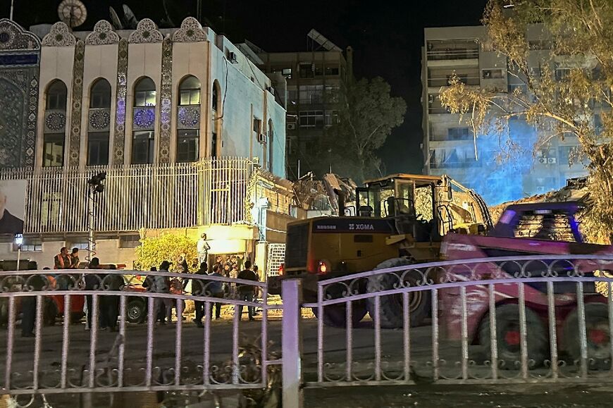 Syrian emergency and security personnel continue to search and remove the rubble early on April 2, 2024 at the site of strikes which hit a building annexed to the Iranian embassy in Damascus 