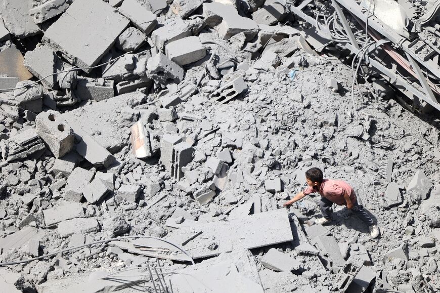 A child looks under debris after an Israeli bombardment the Al-Daraj neighbourhood in Gaza City 