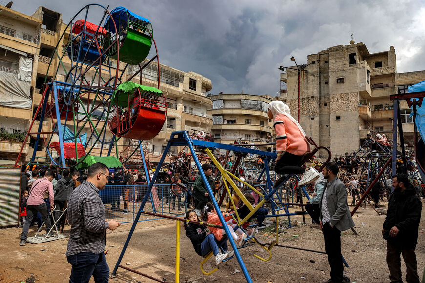 Children sit in joy-rides on the first day of the Muslim holiday of Eid al-Fitr, which comes at the conclusion of the holy month of Ramadan, in the town of Ariha in Syria's rebel-held northwestern Idlib province on April 10, 2024. (Photo by AAREF WATAD / AFP) (Photo by AAREF WATAD/AFP via Getty Images)