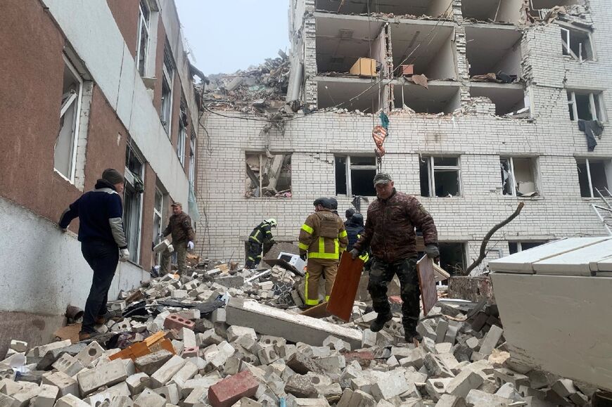 Ukrainian rescuers clear the rubble of a destroyed building following a missile attack in Chernigiv on April 17, 2024