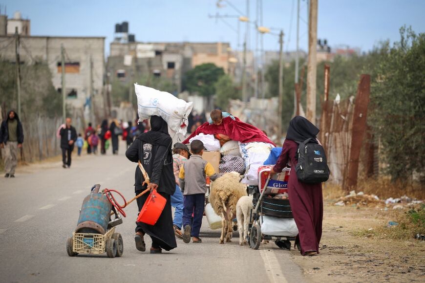 Displaced Palestinians in Rafah, the southern Gaza Strip, carry their belongings following an evacuation order by the Israeli army 