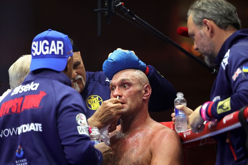 Britain's Tyson Fury (C) receives medical attention from his team during his loss to Ukraine's Oleksandr Usyk in their heavyweight world title unification fight