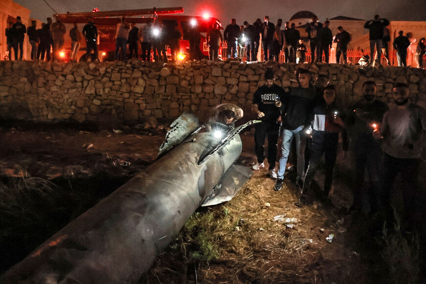 Giovani palestinesi ispezionano un proiettile caduto dopo che l'Iran ha lanciato una raffica di missili contro Israele in risposta all'uccisione del leader libanese di Hezbollah Nasrallah e di altri militanti sostenuti dall'Iran, a Ramallah nella Cisgiordania occupata il 1° ottobre 2024. I rapporti affermano che l'Iran ha lanciato tra 150 e 200 missili nell'attacco, il secondo del paese contro Israele dopo un attacco missilistico e con droni ad aprile in risposta a un mortale attacco aereo israeliano contro il consolato iraniano a Damasco. (Foto di Zain JAAFAR / AFP) (Foto
