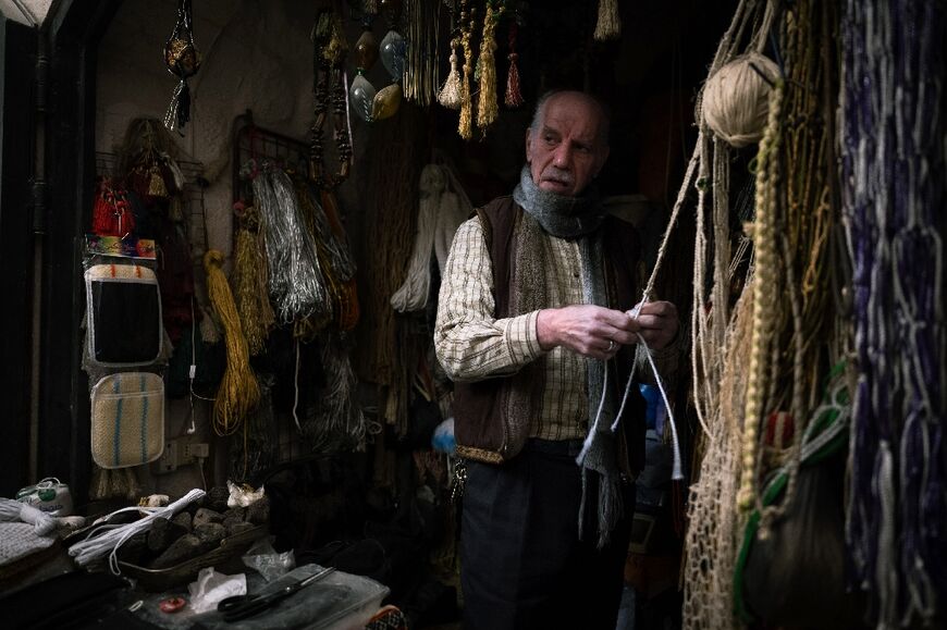 Jamal Habbal, a 66-year-old shopkeeper, works at his stall in a traditional market area in Aleppo