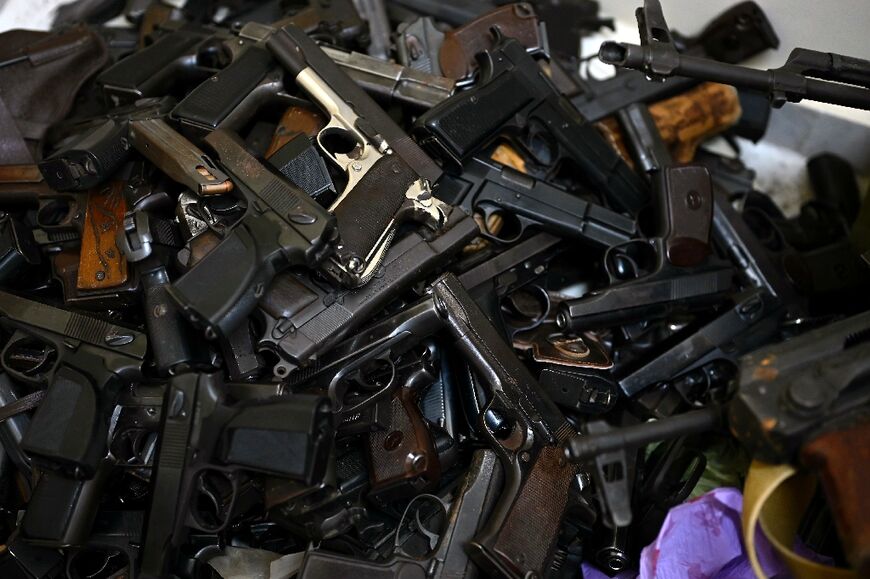 Pistols, automatic rifles, ammunition, grenades and even a grenade launcher packed into a garbage bag piled up at the back of the room