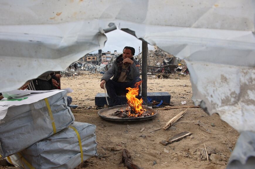 A returning resident of the north Gaza town of Jabalia lights a fire outside a makeshift tent.