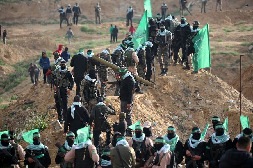 Hamas fighters gather for the handover of the four coffins at a former cemetery in the south Gaza city of Khan Yunis.