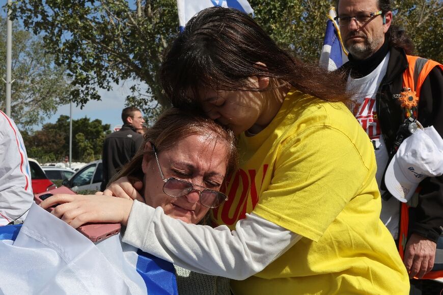 Le donne israeliane piangono all'arrivo del convoglio di veicoli che trasporta i corpi dei quattro ostaggi israeliani