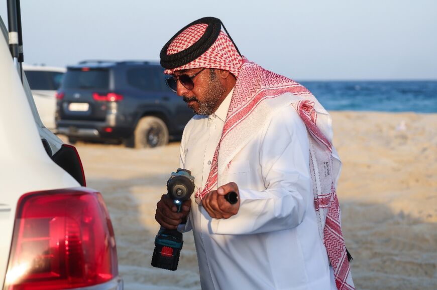 A rescuer from Aoun Qatar prepares to assist a vehicle stuck in the sand in Al Wakrah