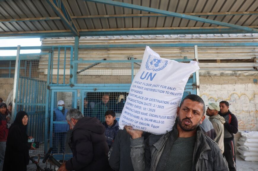 A Palestinian receives food aid from a United Nations distribution centre in Nuseirat refugee camp, central Gaza, after Israel announced a block on aid flows into the territory